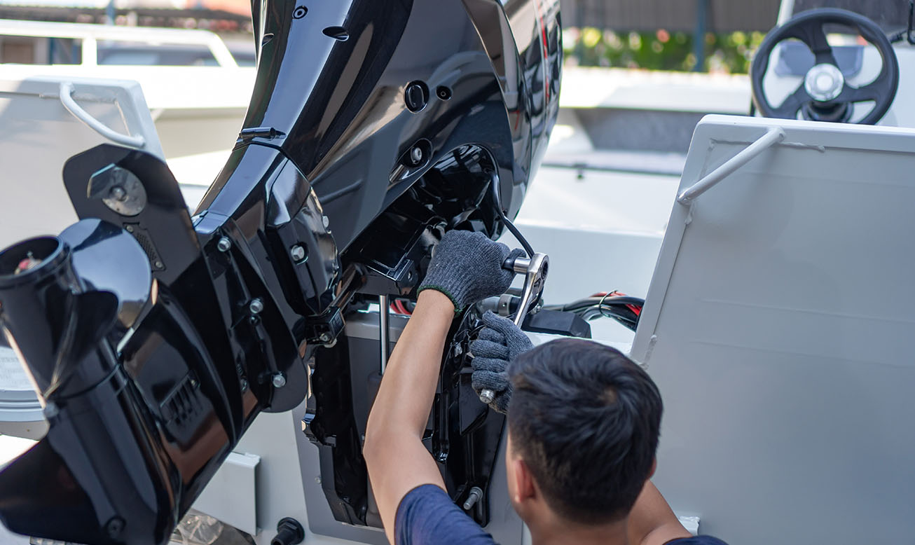 Technician servicing an outboard motor during boat engine service
